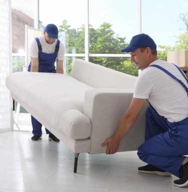 Two-Male-Movers-Moving-A-Furniture Two-Male-Movers-Moving-A-Furniture